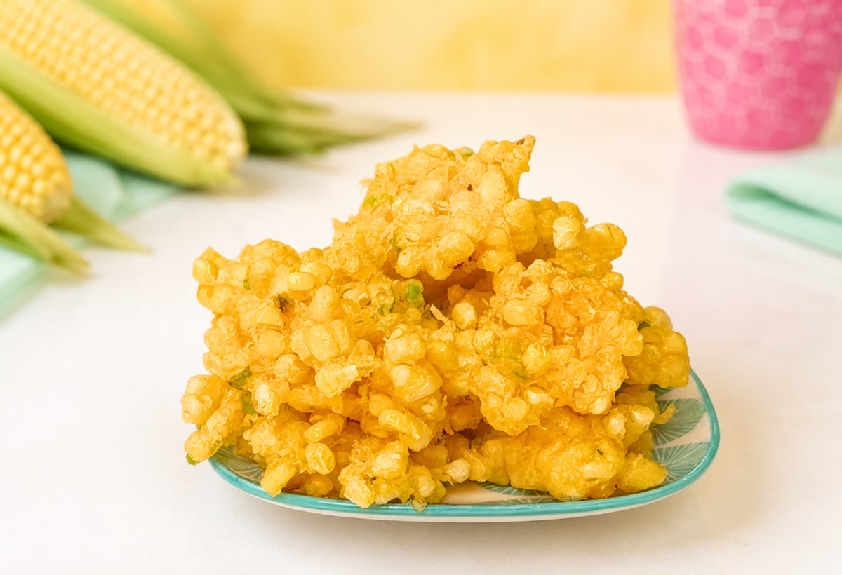 Crispy tempura corn fritters piled on a plate